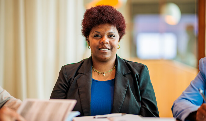 Vrouw in leslokaal kijkt in de camera