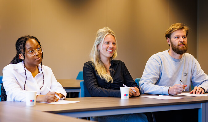 Personen luisterend in leslokaal