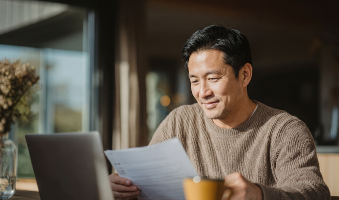 Man achter laptop bekijkt documenten
